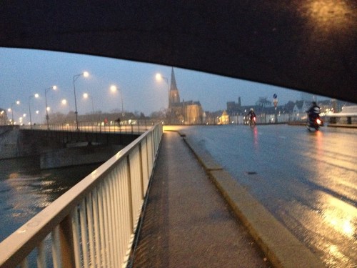 Natte straten weerkaatsen het schijnsel van lantarens. Verscholen onder mijn plu volg ik het goudgele spoor naar het station.