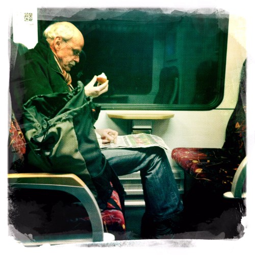 In het donker naar huis. De man met zijn appel, breeduit, geen aandacht voor de omgeving.