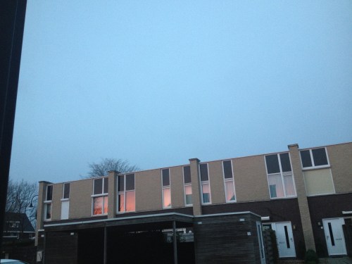 De ramen aan de overkant weerspiegelen het ochtendlicht. Ik weet wat me boven te wachten staat.