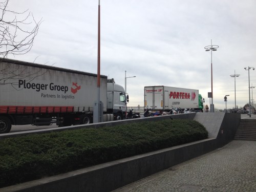 Grote vrachtwagens blokkeren ons zicht. 