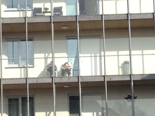 Onderweg naar huis langs de seniorenflat. Zo kan het ook, op de galerij languit van de zon genieten.