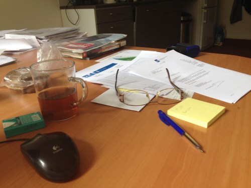 Aan het werk, papieren hier, papieren daar.